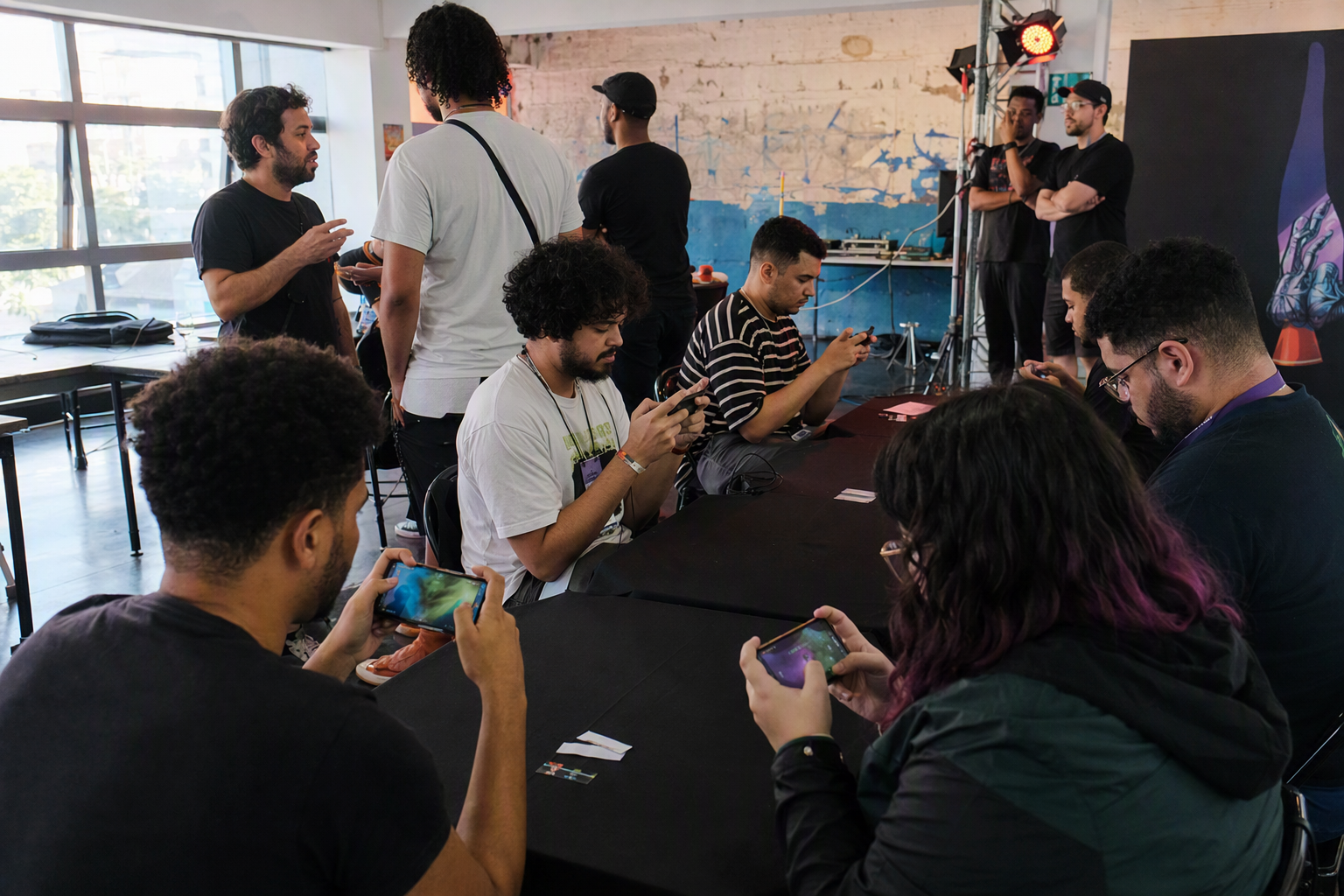 A diverse team practicing on mobile devices in a São Paulo tournament studio
