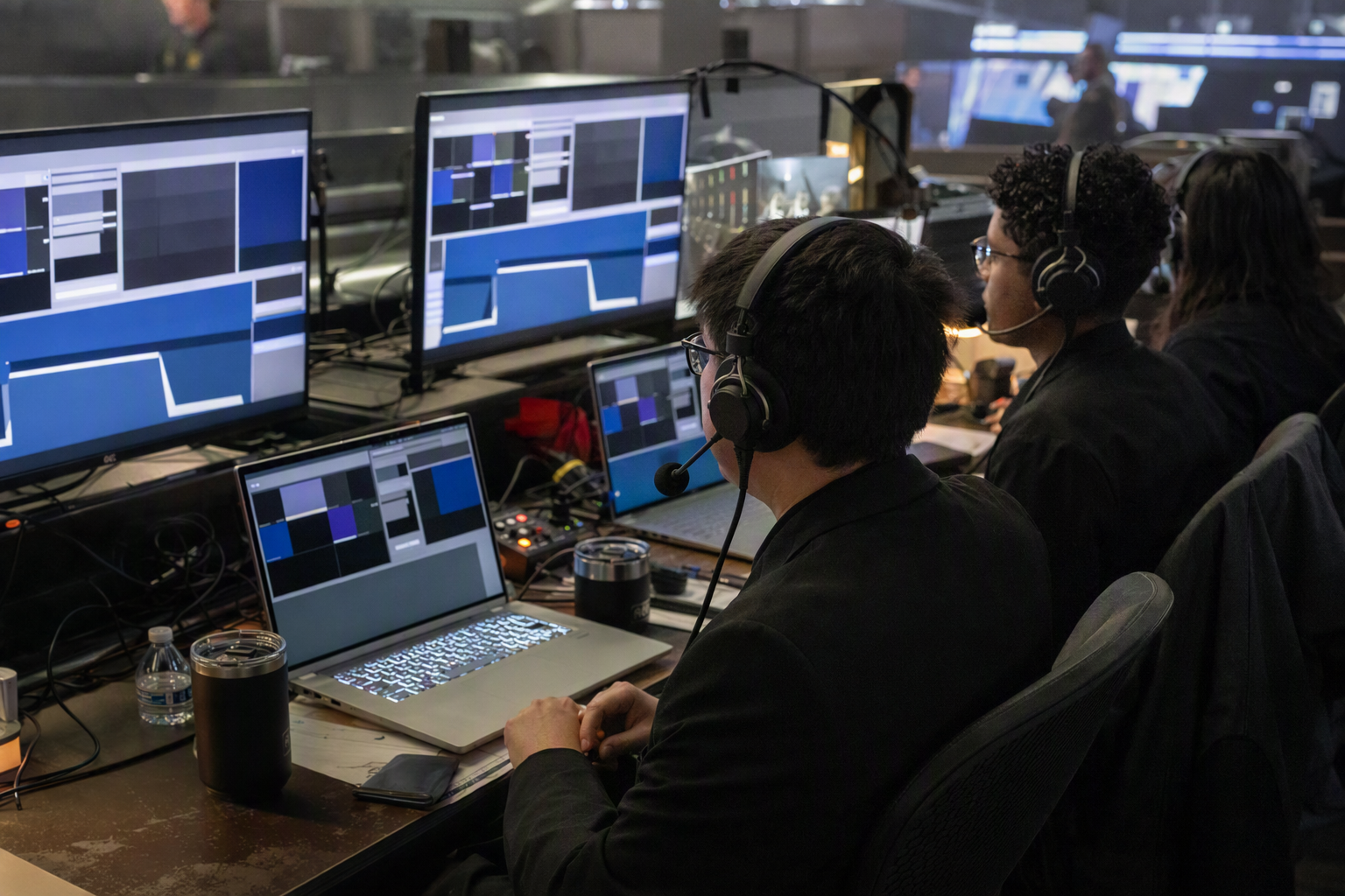 Referees monitoring an independent mobile esports tournament from a compact operations desk